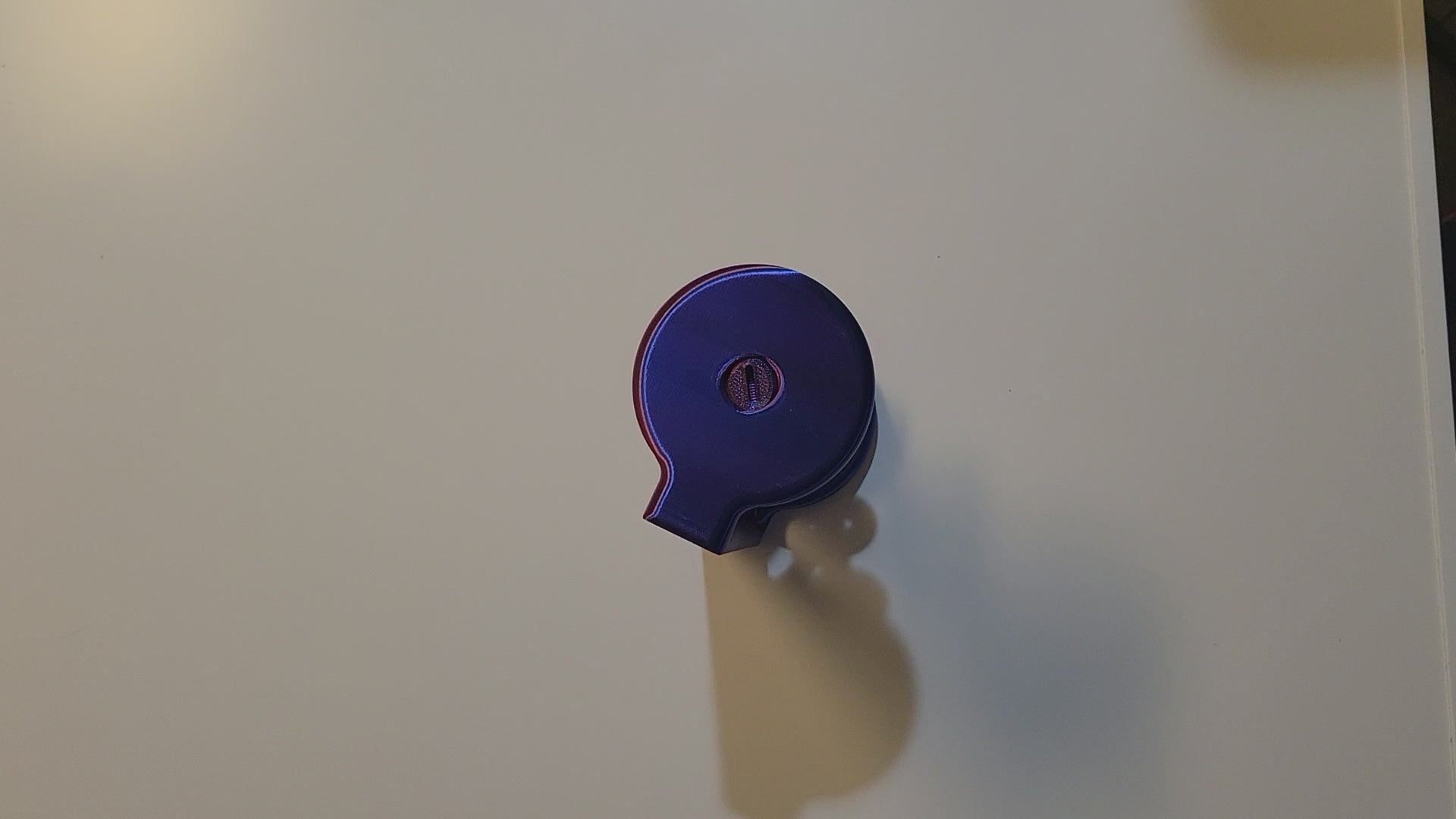 Blue to Purple 3D-printed spinning helix desktop fidget displayed by 2 hands holding and spinning the center piece to show function on light grey backdrop.