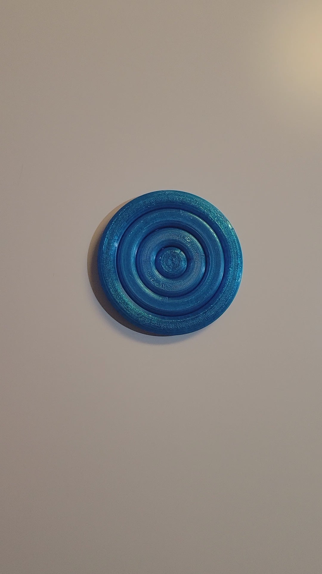 Translucent Blue 3D-printed orbital gyro desktop fidget displayed by 2 hands rotating a design that spins in all directions and lays flat when done.