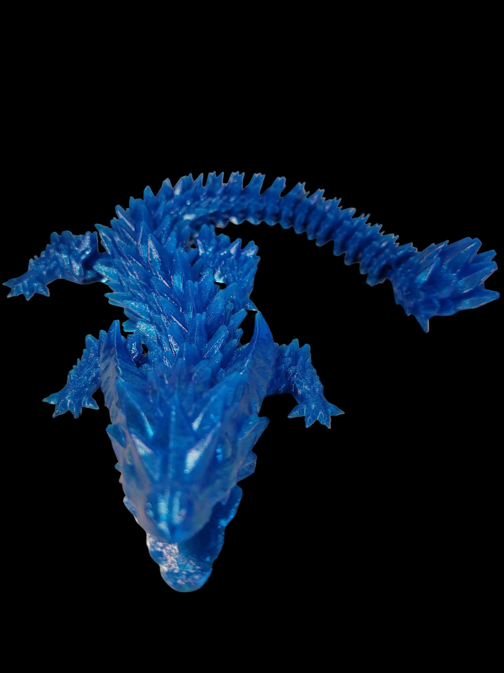 Translucent Blue 3D-printed wingless articulated dragon with jagged crystalized scales and functional jaw on a black background.