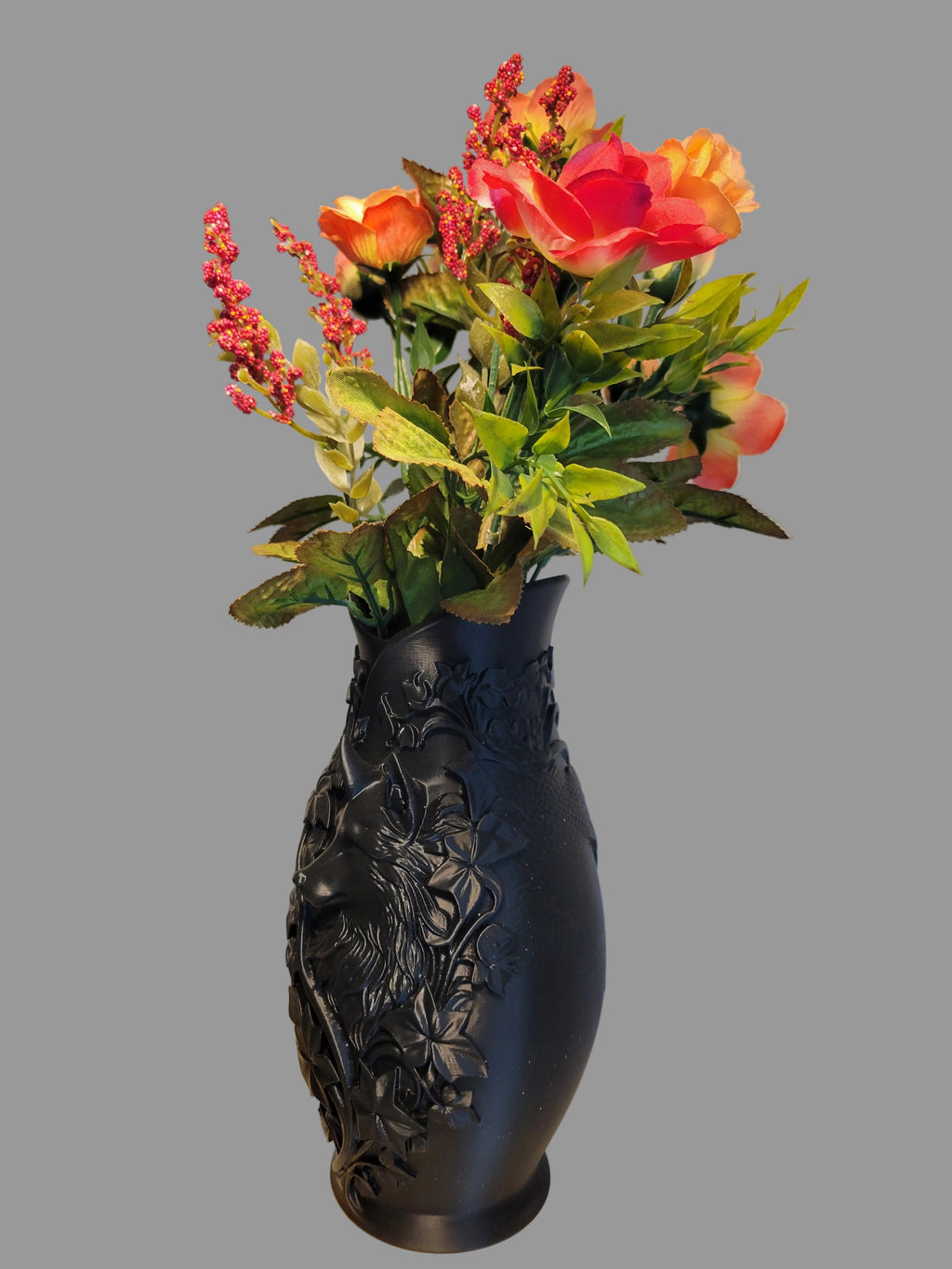 Onyx Black 3D-printed wolf vase with intricate floral details showing angled view holding orange flowers against a gray background.