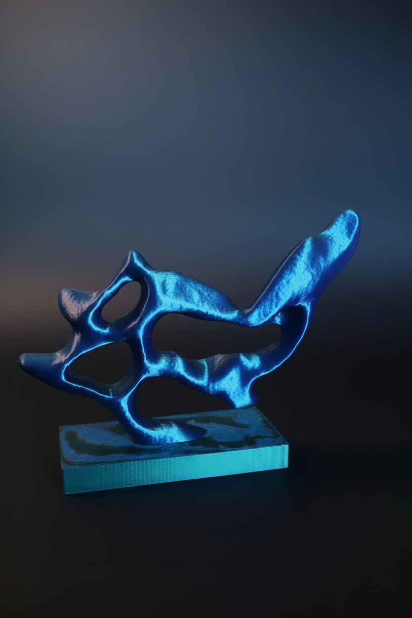 Blue to Green Silk color-shifting 3D-printed wavy flow sculpture reflecting light on a gray background.