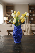 Cobalt Blue 3D-printed vase with detailed Koi fish featuring intricate waves and lotus holding tulips on a dark wood dining table.