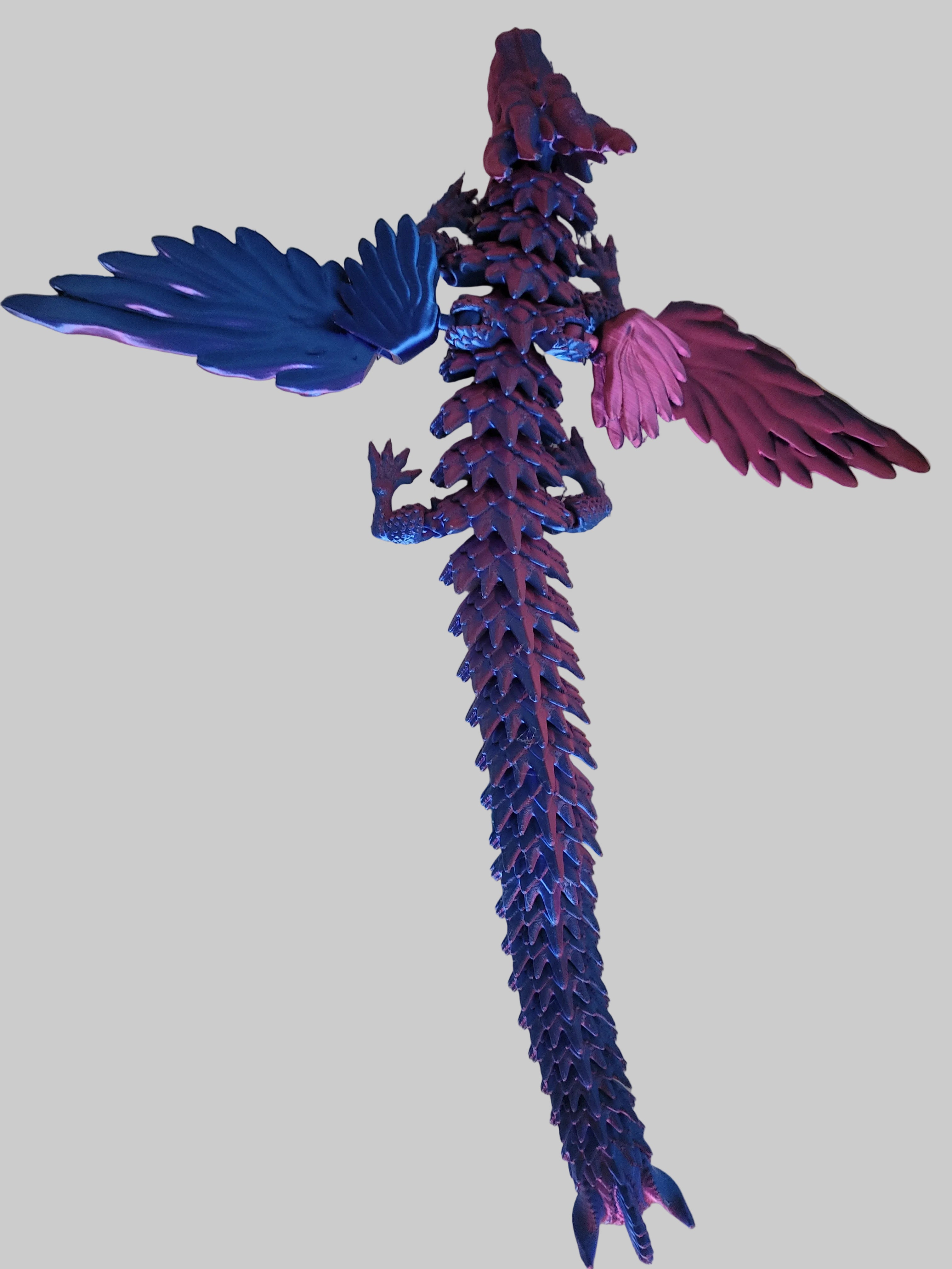 Blue to Purple Silk color-shifting 3D-printed articulated dragon with functional wings and jaw on white backdrop.