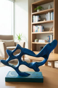 Blue to Green Silk color-shifting 3D-printed abstract flow sculpture on a table with a blurred living room background.