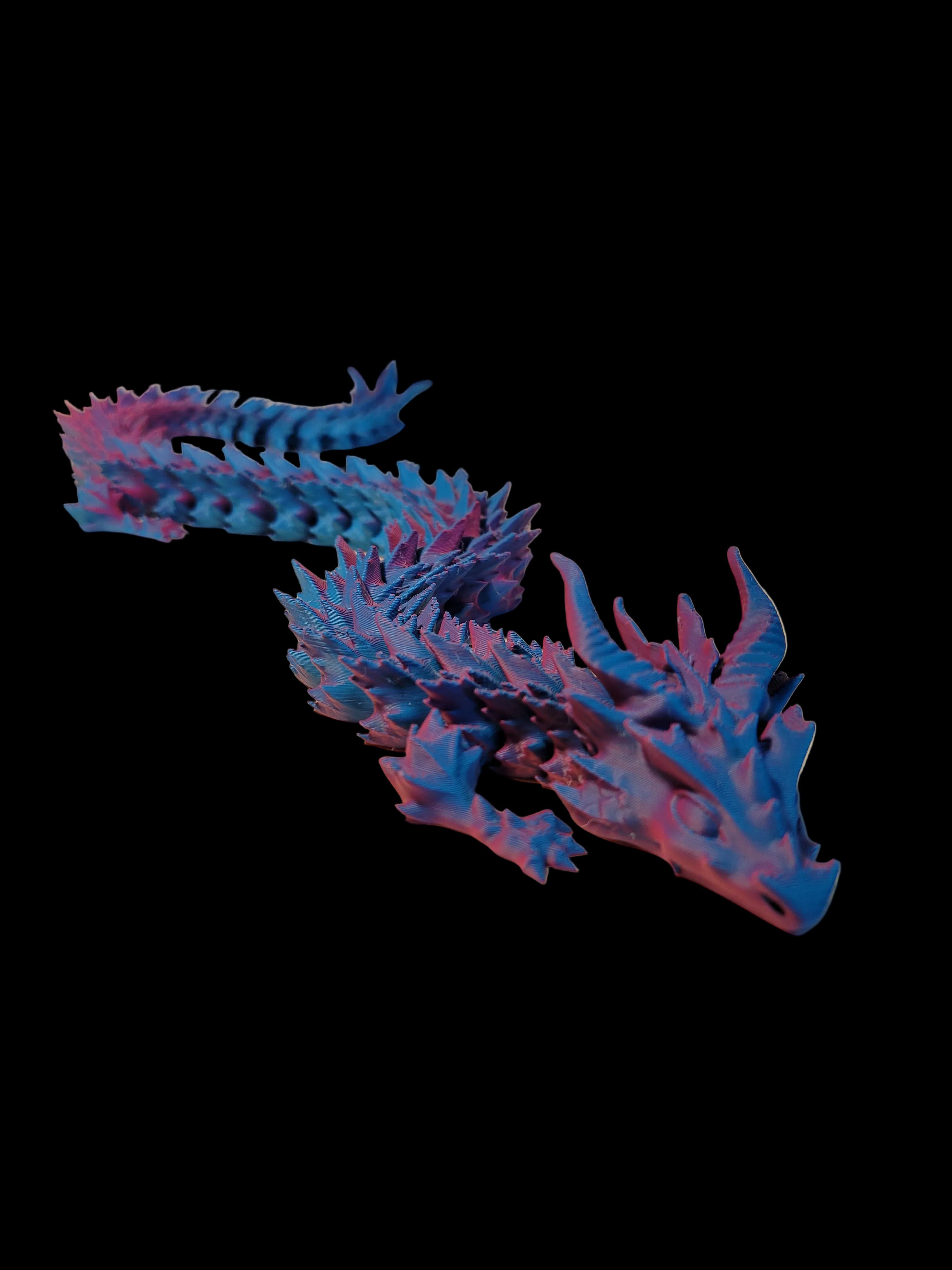 Teal to Pink color-shifting 3D-printed wingless articulated dragon shown as if in motion on a black background.