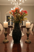 Onyx Black 3D-printed vase with intricate wolf and floral designs holding pink roses centered on a dining table by candles.