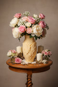 Sandstone Beige 3D-printed butterfly vase with raised floral and leaf designs holding pink and white roses on a table.