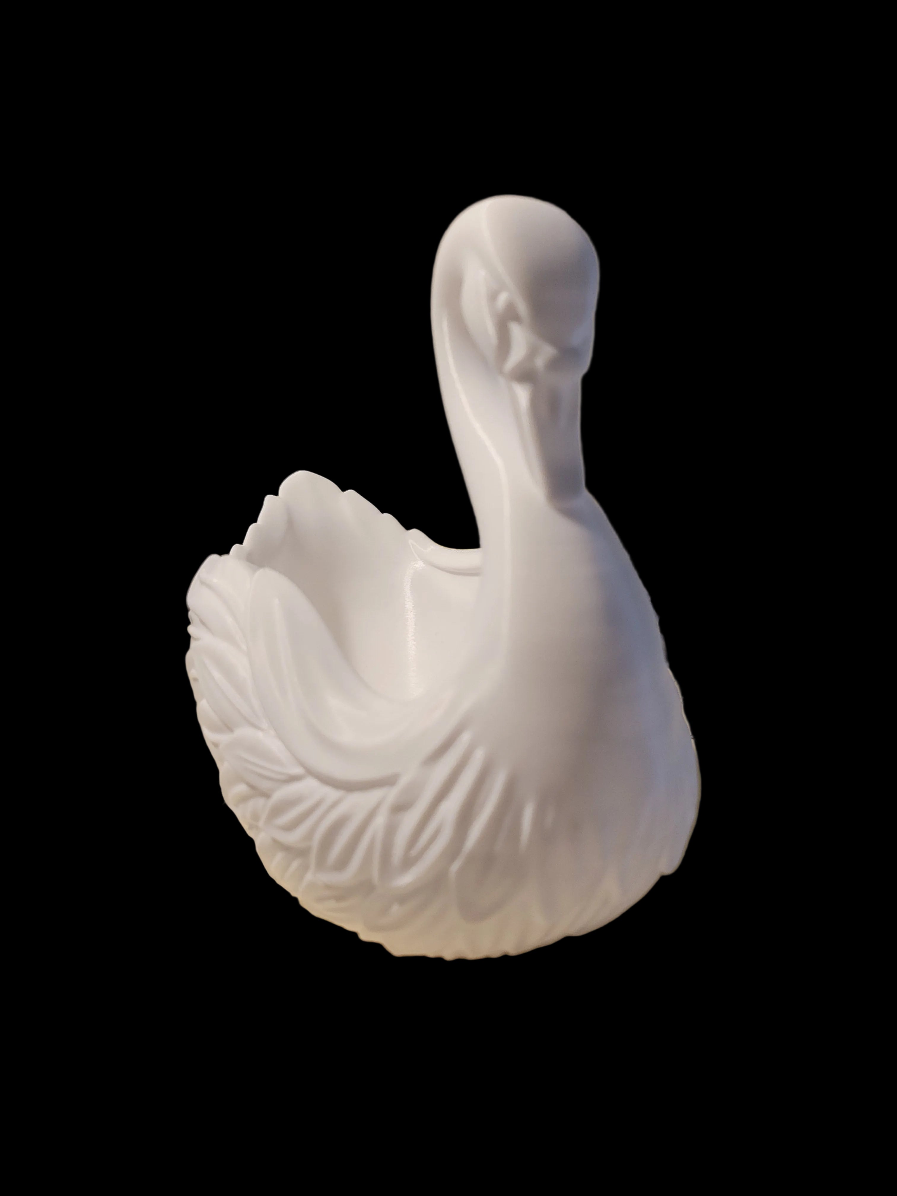 Arctic White 3D-printed catch-all tray sculpted with the feathered elegance of a swan tipping its beak to its chest on a black background.