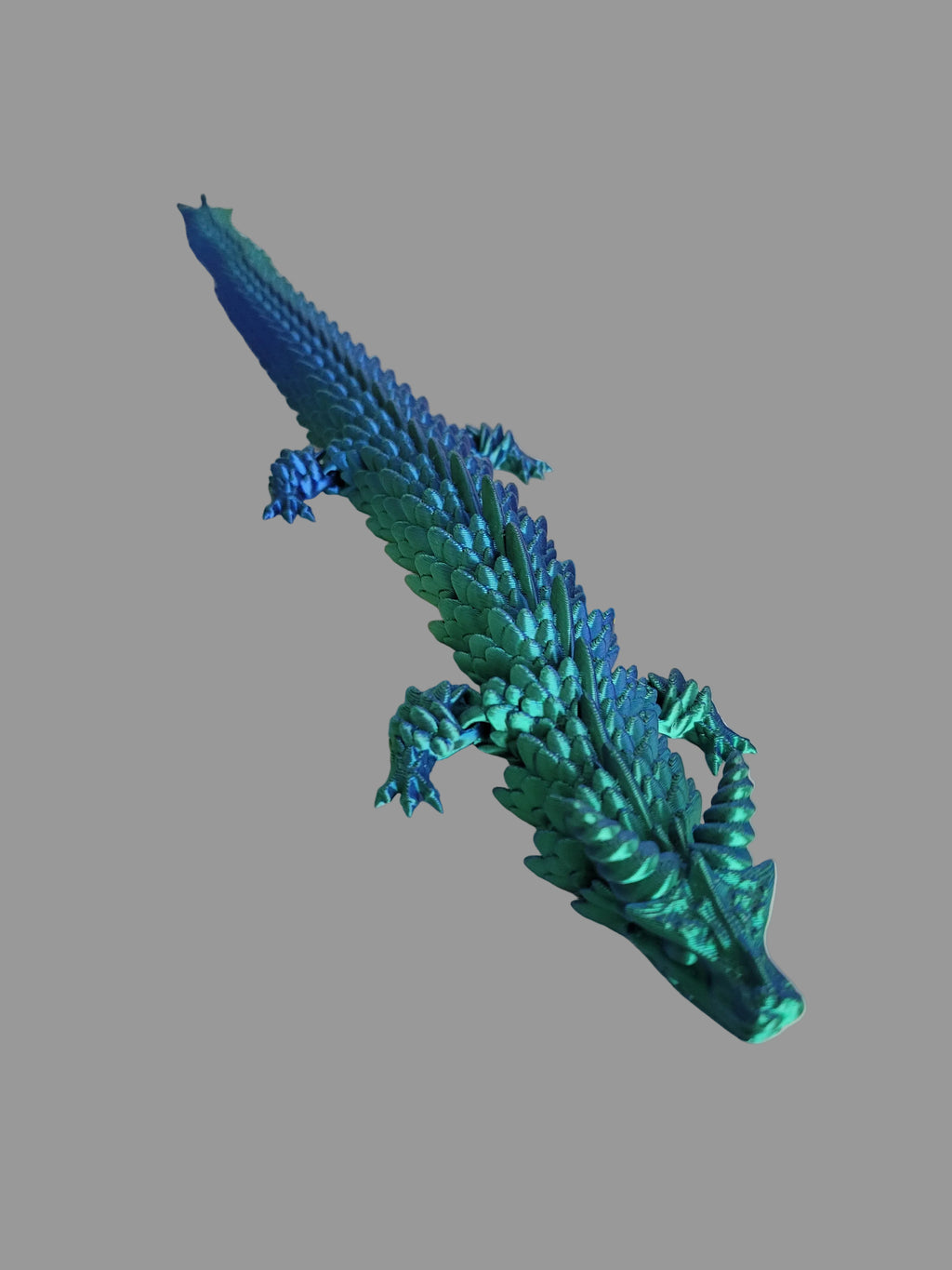 Blue to Green Silk color-shifting 3D-printed articulated dragon on a light gray background.